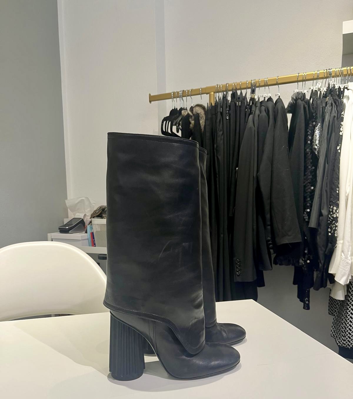 Stiefel vor einer Stange mit dunkler Mode