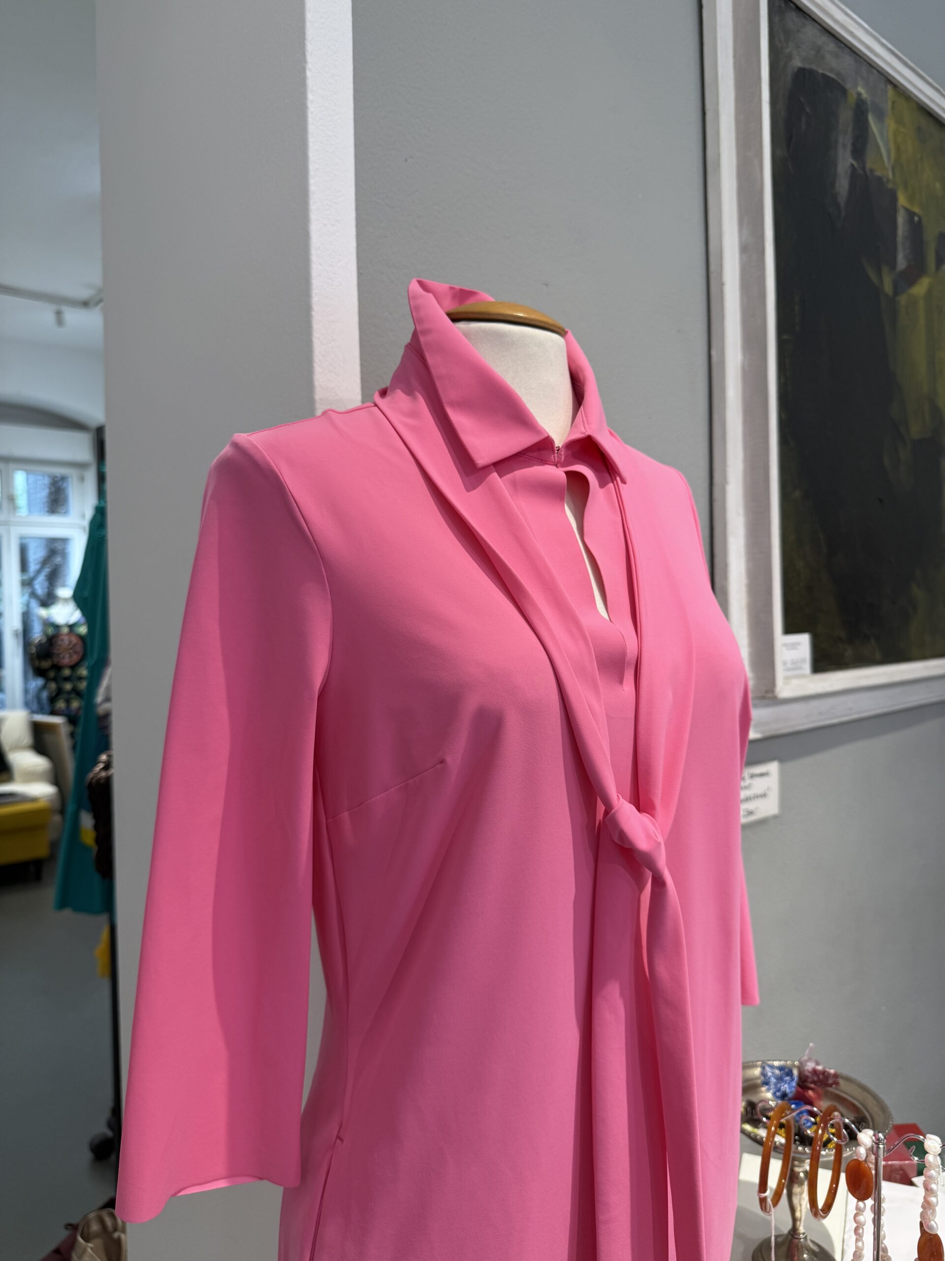 Pinke Seidenbluse an der Büste vor einem Originalgemälde