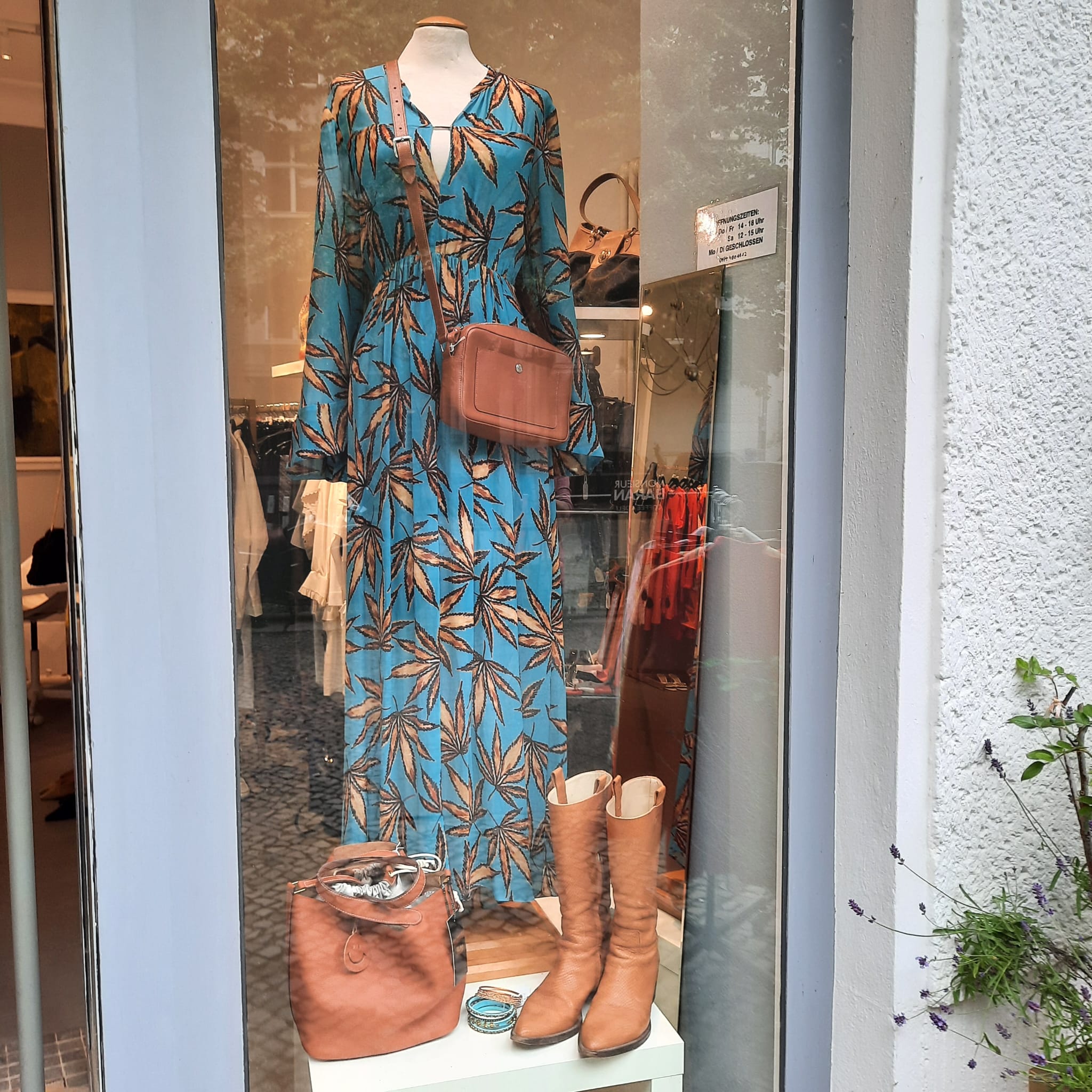 Schaufenster mit türkisfarbenem Maxikleid und Stiefeletten